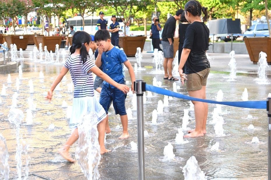 Children in Seoul in summer playing in the water at Cheonggye Plaza